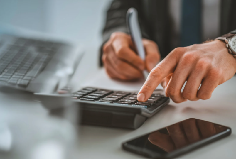 Mains calculant le salaire minimum sur une calculatrice